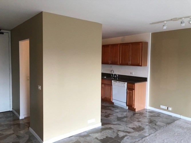 A kitchen with brown cabinets and a white dishwasher.