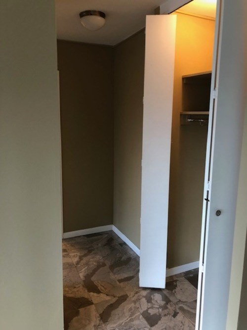 A hallway with a white door and brown walls.