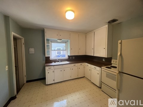 A kitchen with white cabinets and a window.
