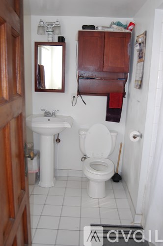 A bathroom with a toilet, sink, and medicine cabinet.