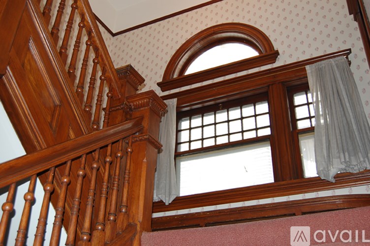 A wooden staircase with a window above it.