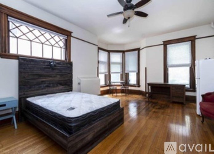 A bedroom with a large bed and a ceiling fan.