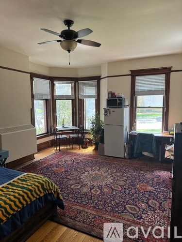 A bedroom with a bed, a ceiling fan, and a rug.
