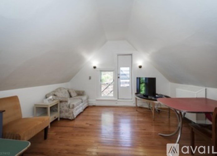 A living room with a couch, chair, and television.