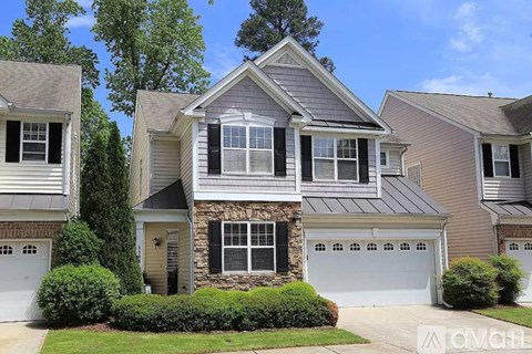 A house with a stone pillar in front of it.