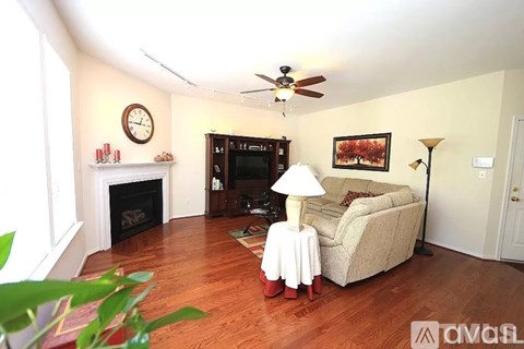 A living room with a fireplace, a couch, a lamp, and a painting on the wall.