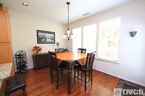 A dining room with a wooden table and chairs.