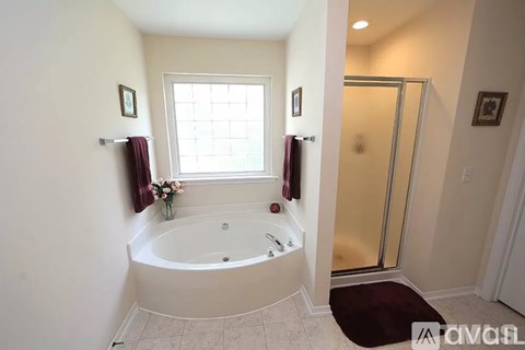 A bathroom with a tub and a window.