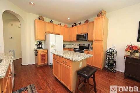 A kitchen with wooden cabinets and a white fridge.