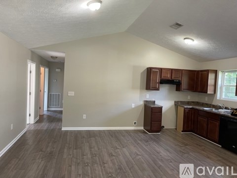 A kitchen with wooden cabinets and a countertop is available for rent.