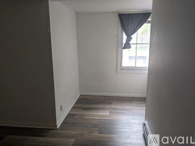 A room with a window and wooden flooring.
