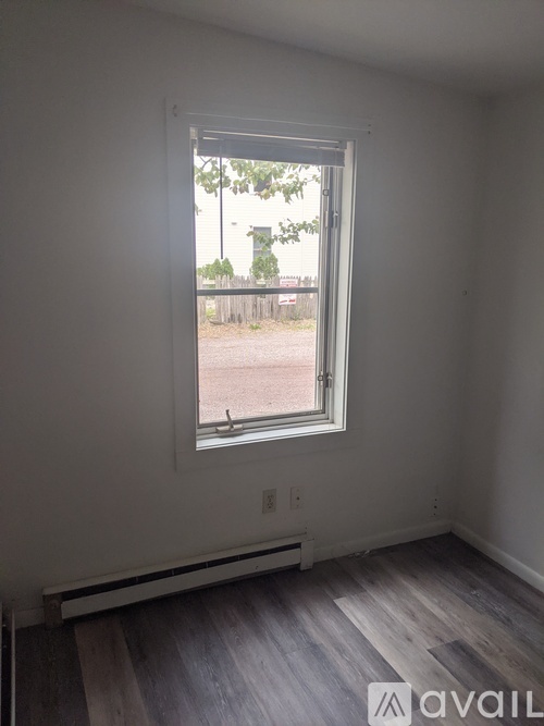 A room with a window and wooden flooring.