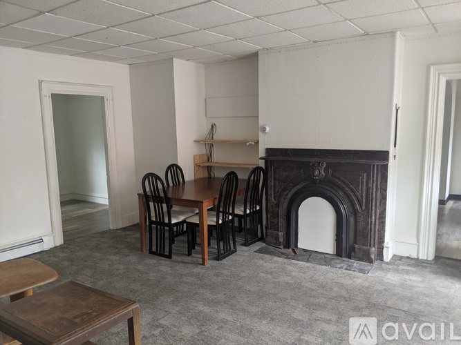 A room with a fireplace and chairs.