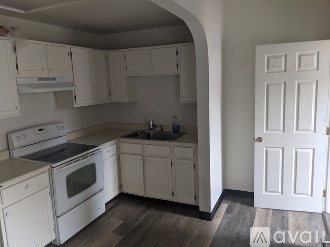A kitchen with white cabinets and appliances.
