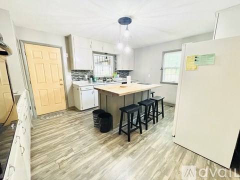 A kitchen with a table and chairs in the middle of the room.