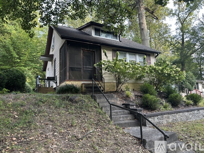 A house with a brown door is surrounded by trees.