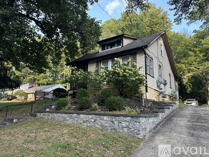 A house with a stone wall in front of it.