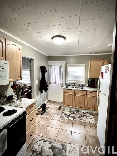 A kitchen with a white stove top oven and a white refrigerator.