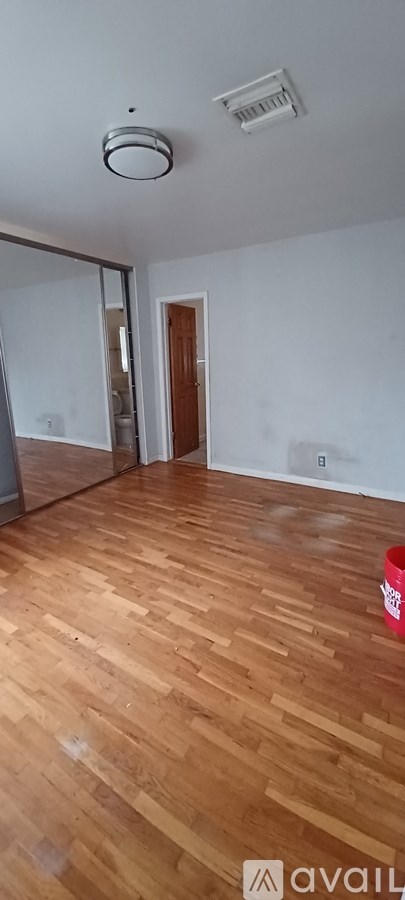A room with wooden flooring and a ceiling fan.