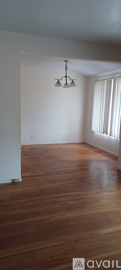 A room with wooden floors and a chandelier.