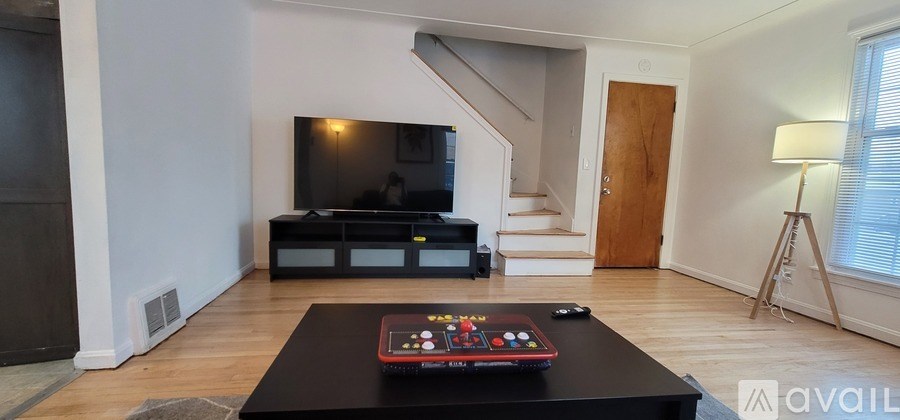 A black coffee table with a remote on it in a living room.