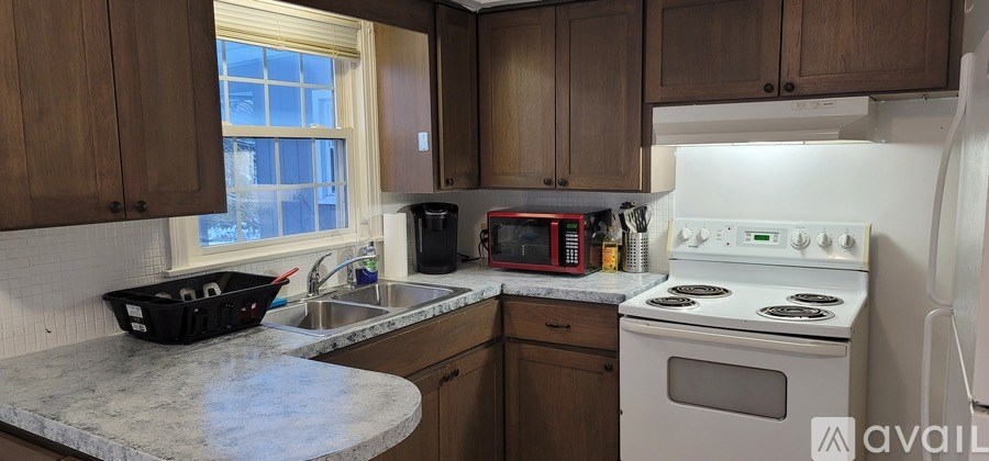A kitchen with a white stove and wooden cabinets.