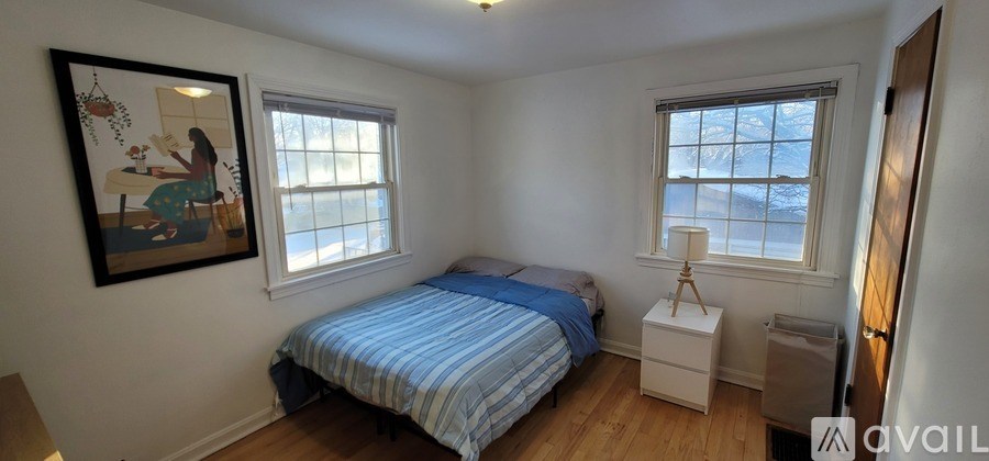 A bedroom with a bed, nightstand, and window.