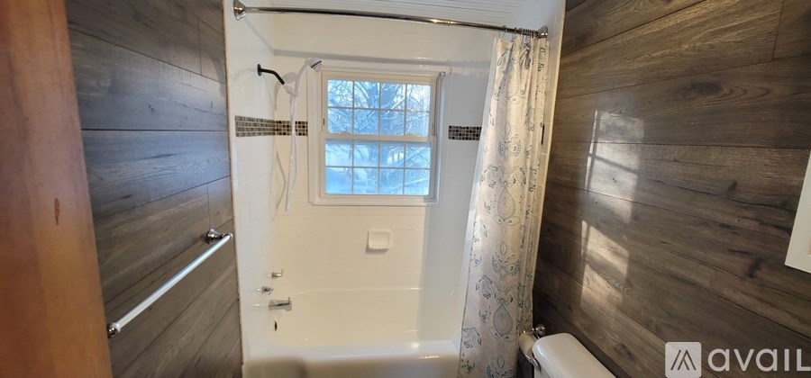 A bathroom with a window and a toilet.