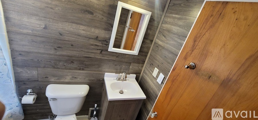 A bathroom with a toilet, sink, and mirror.