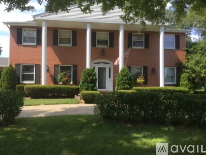 A red brick house with a white door and windows.