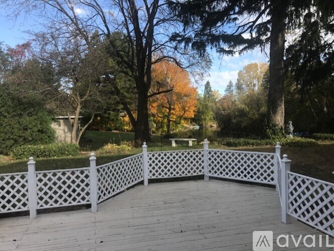 A wooden deck with a lattice fence and trees in the background.