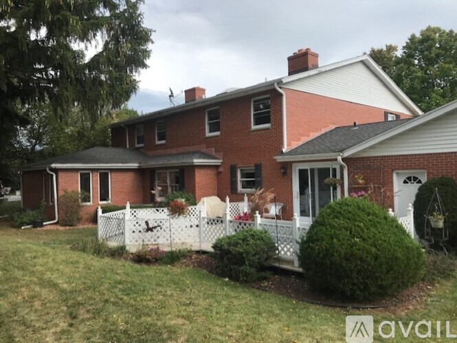 A red brick house with a white picket fence.