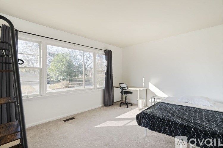 A bedroom with a bed, desk, and chair.