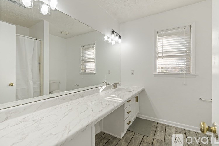 A bathroom with a marble countertop and a large mirror.