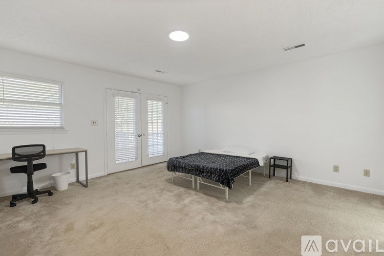 A bedroom with a bed, desk, and chair.