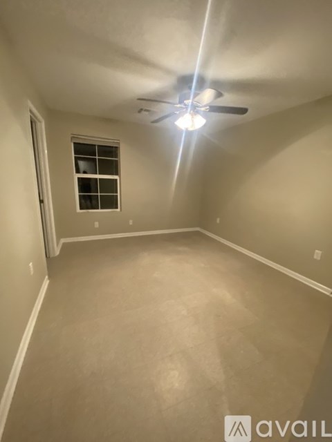 A room with a ceiling fan and a window.