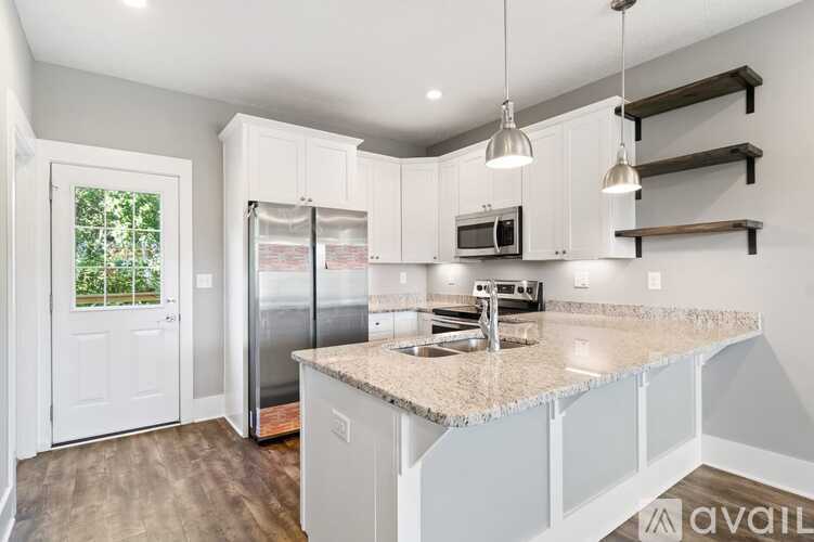 A kitchen with white cabinets and a granite countertop.