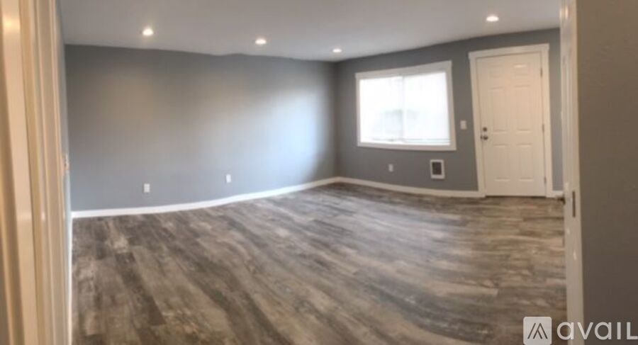 A room with a wooden floor and a window.