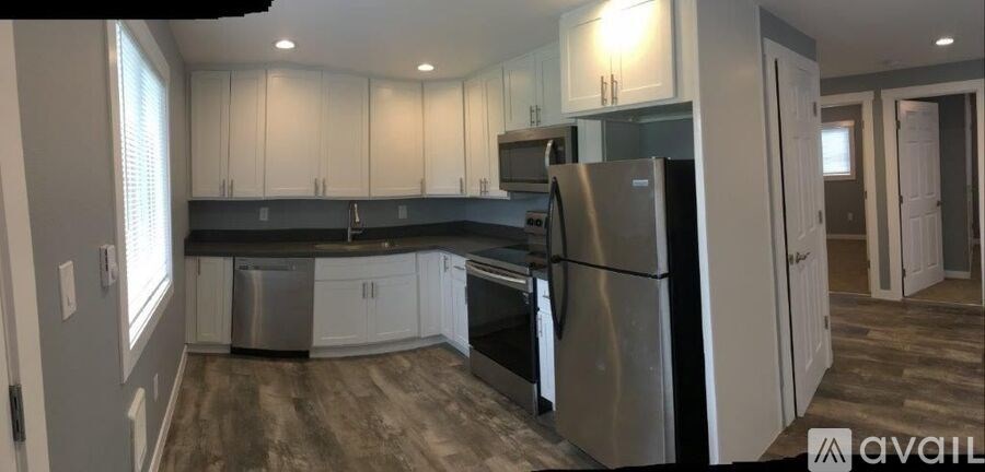 A kitchen with white cabinets and a black countertop.