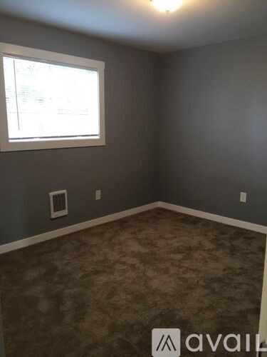A room with a carpeted floor and a window.