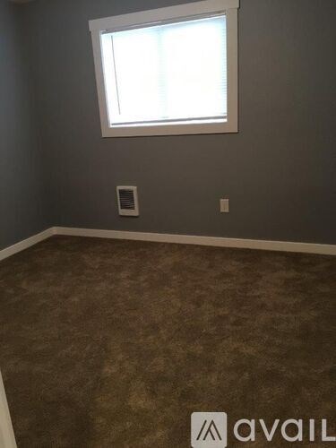 A room with a carpeted floor and a window.