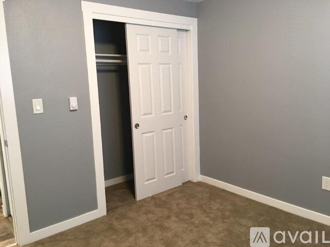 A white door is open to a darker room.