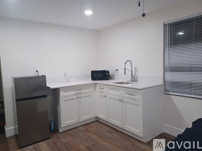 A kitchen with white cabinets and a stainless steel refrigerator.