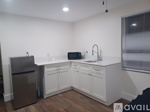 A kitchen with white cabinets and a stainless steel refrigerator.