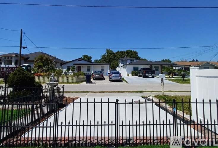 A black metal fence surrounds a white gate.