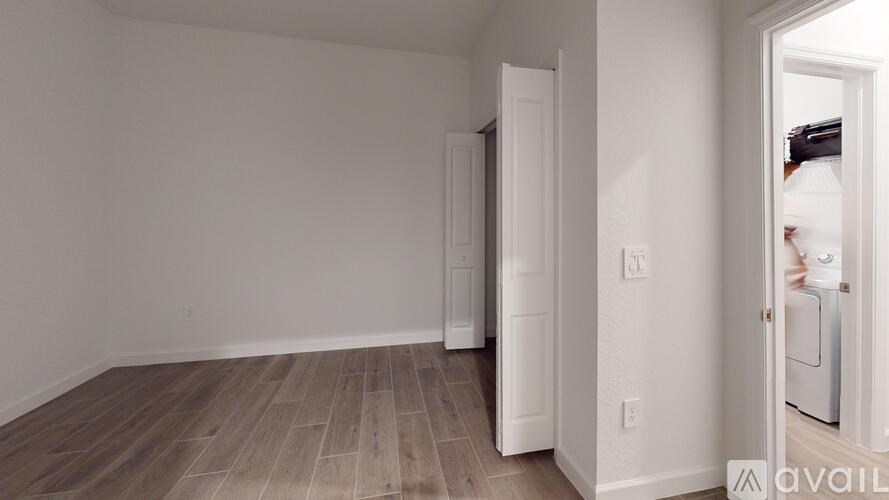 A room with a white door and a white wall.