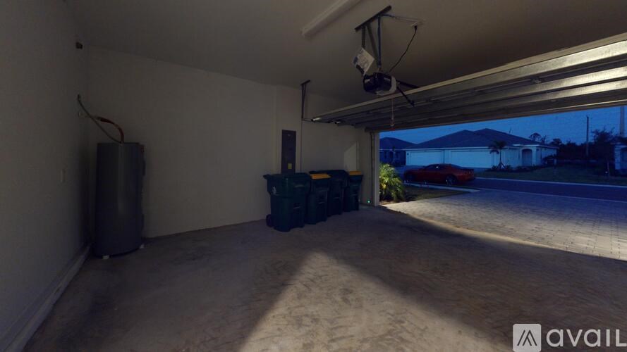 A room with a white wall and a window showing the outside view.