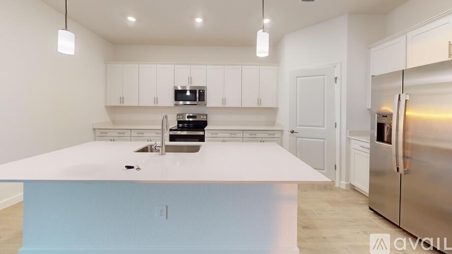 A kitchen with white cabinets and a stainless steel refrigerator.