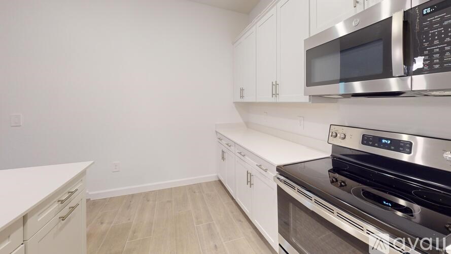 A kitchen with white cabinets and a stainless steel oven.