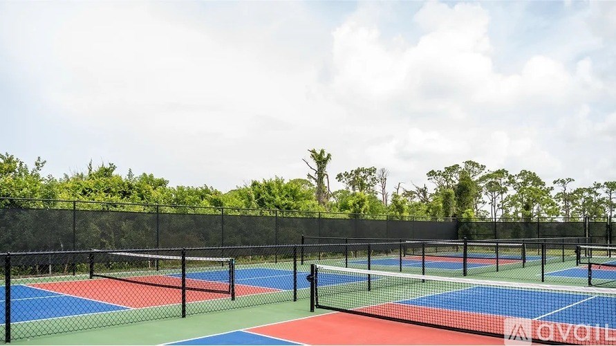 A tennis court with a red, blue and green surface.